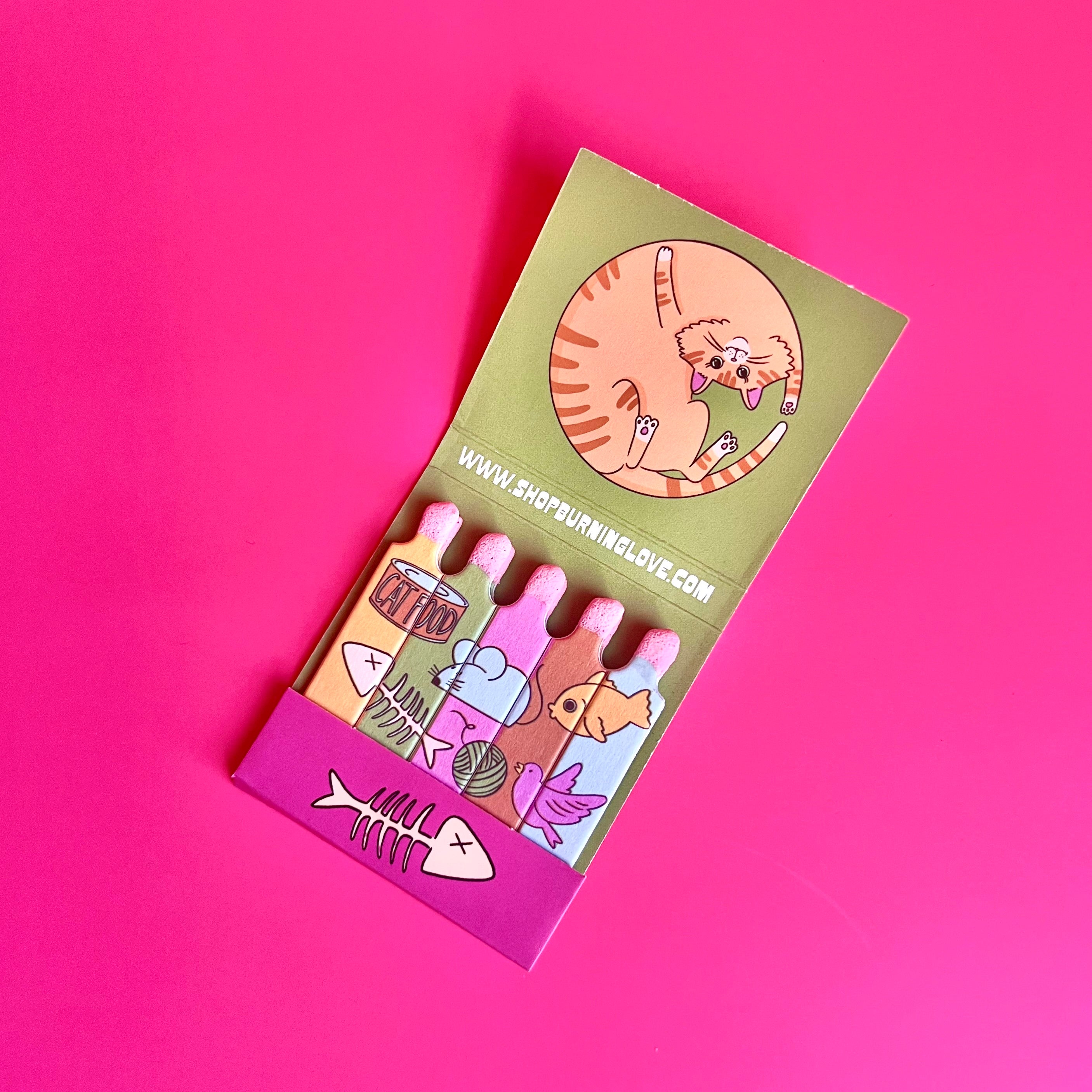 Inside the cat matchbook showing an orange cat curled up with cat foods and toys depicted on the individual matches