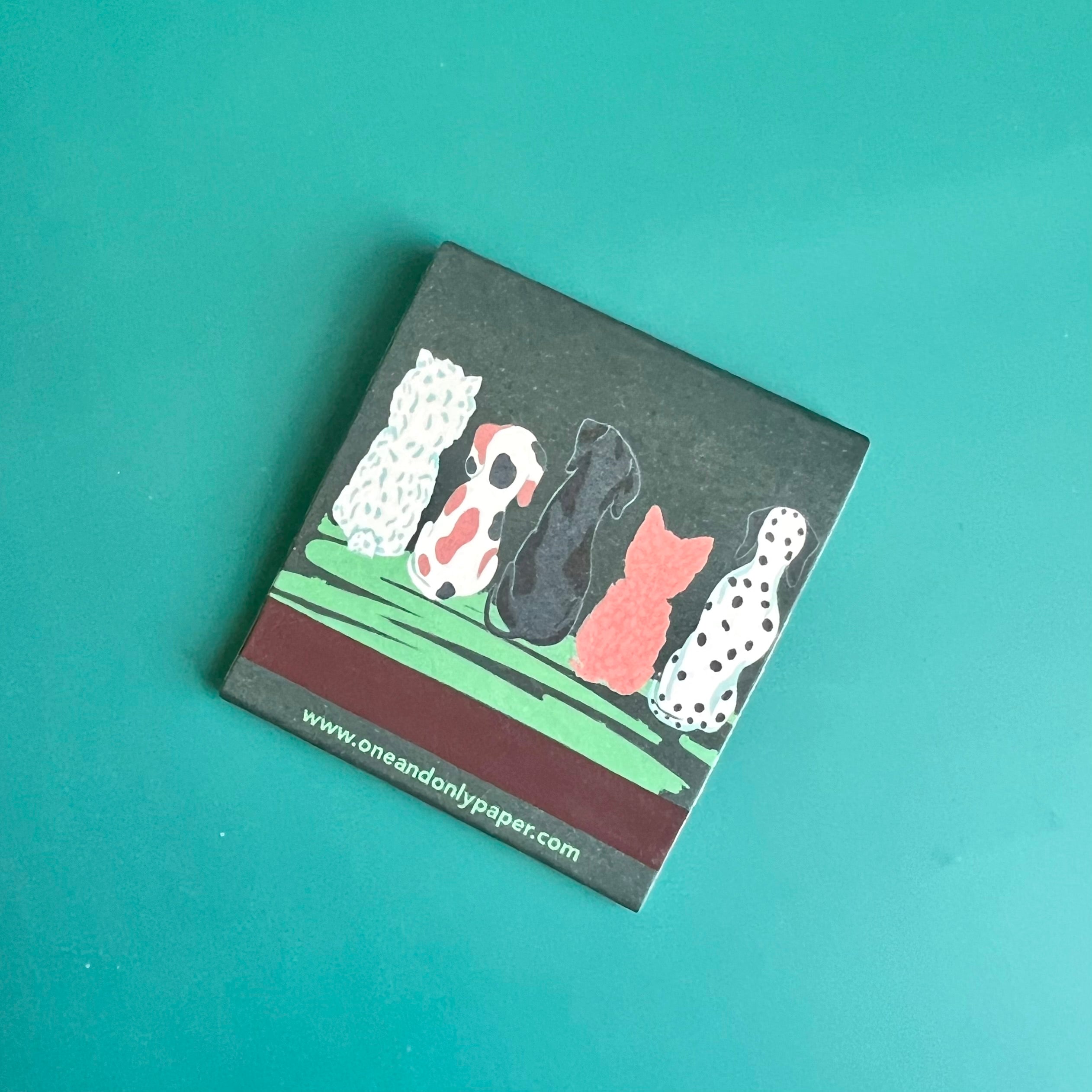 Back of dog matchbook showing the backs of the dogs from the front side with the match-striking bar on the bottom