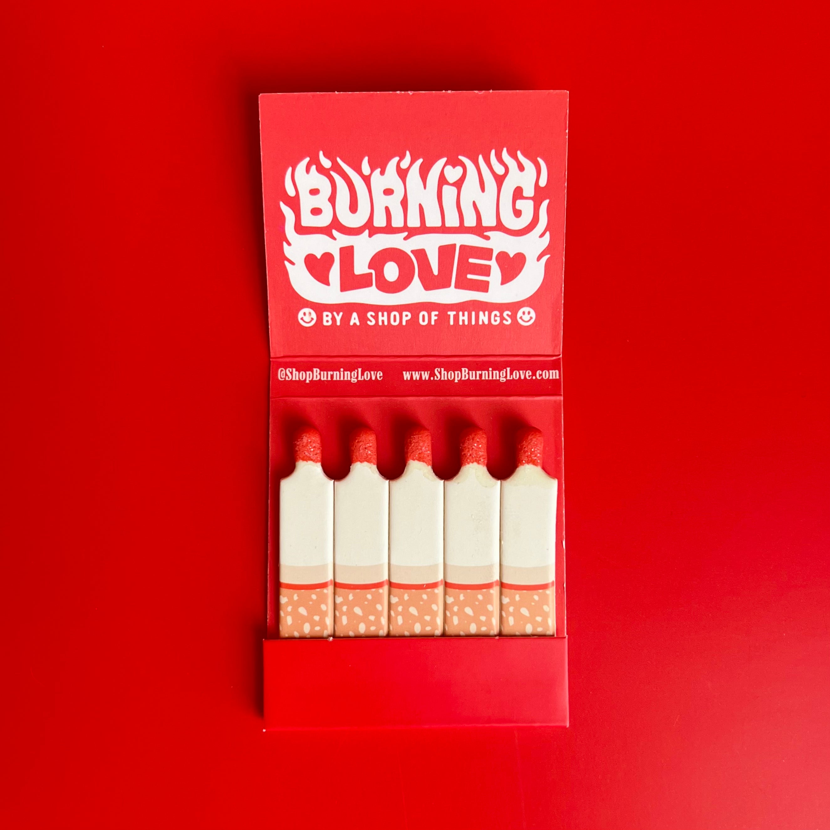 Inside of the cigarette matchbook featuring the words “Burning Love” with each matchstick illustrated to depict individual cigarettes