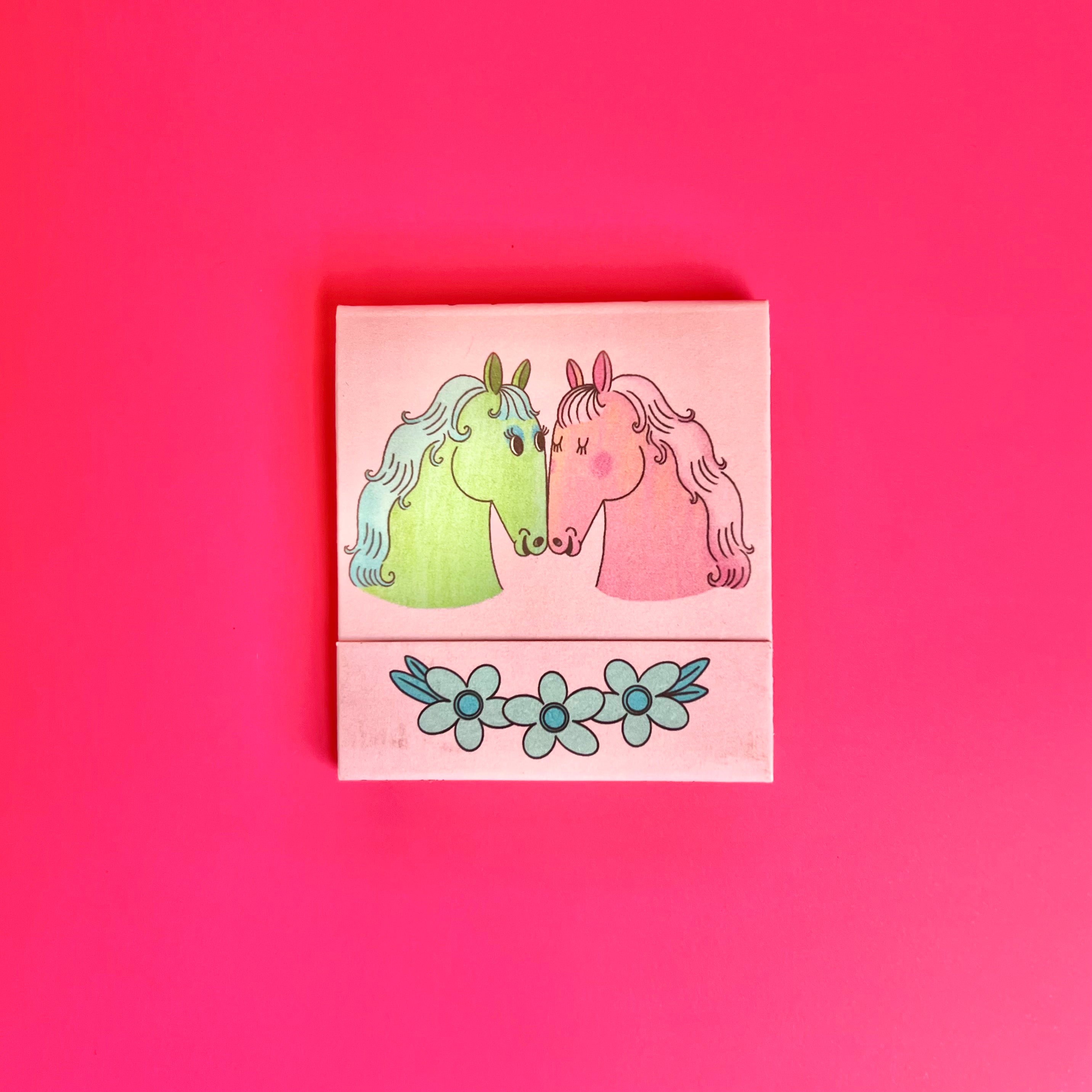 Front of horse matchbook depicting two illustrated, colorful horses 