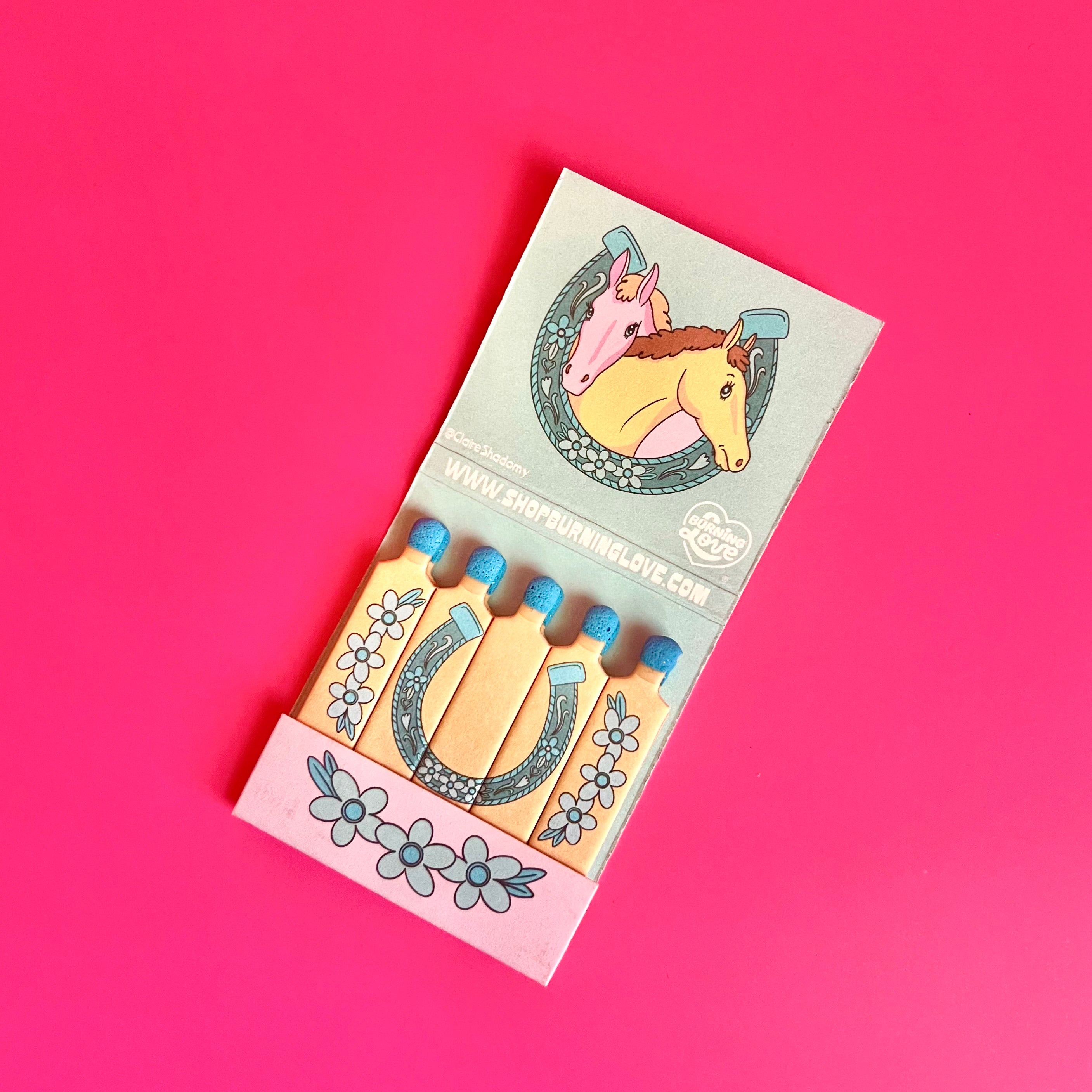 Inside of horse matchbook showing horses on the top and a horseshoe design on the actual matchsticks