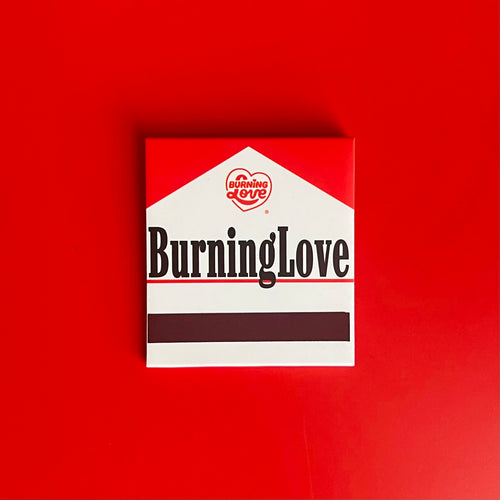 Back of Cigarette Matchbook depicting the words “Burning Love” with the match-striking bar on the bottom 