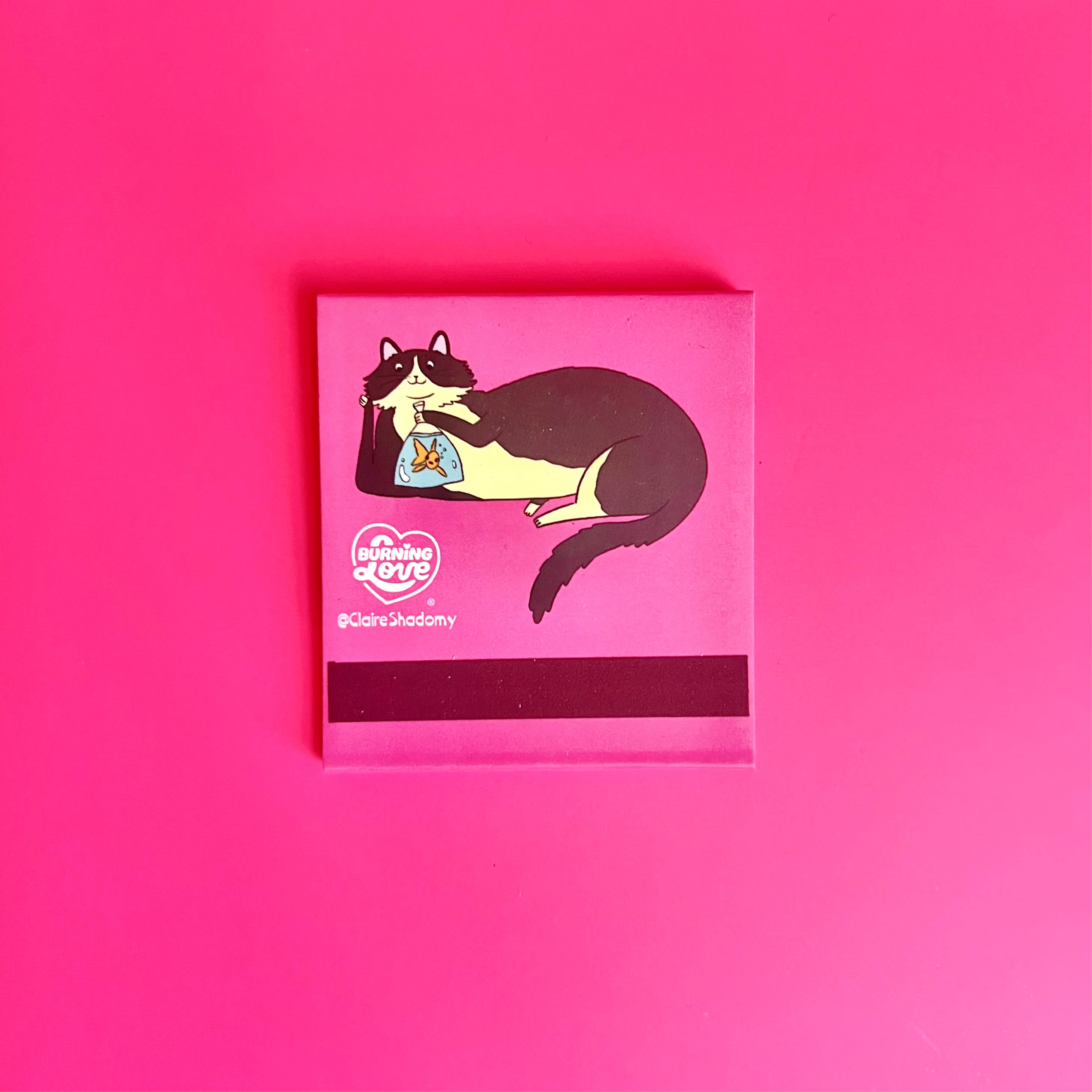 Back of cat matchbook showing a black-and-white cat lounging and the match-striking bar at the bottom